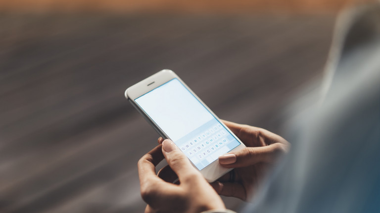 Girl,Pointing,Finger,On,Screen,Smartphone,On,Background,Wooden,Floor