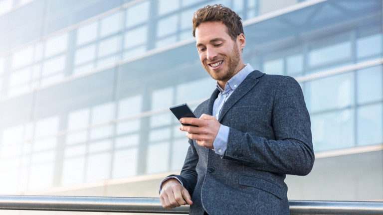 Businessman,Using,Mobile,Phone,App,Texting,Outside,Of,Office,In